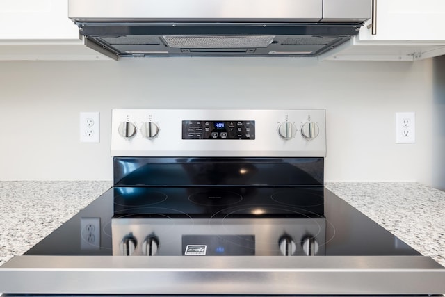 room details with light countertops, ventilation hood, and white cabinets