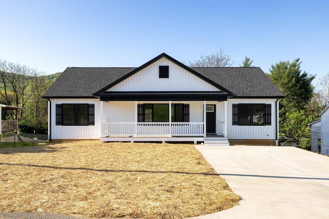 modern farmhouse featuring covered porch, driveway, and roof with shingles