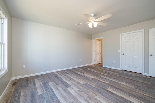 unfurnished bedroom with visible vents, a ceiling fan, baseboards, and wood finished floors