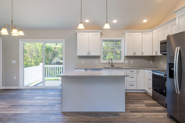 kitchen featuring a sink, a center island, stainless steel appliances, and white cabinetry