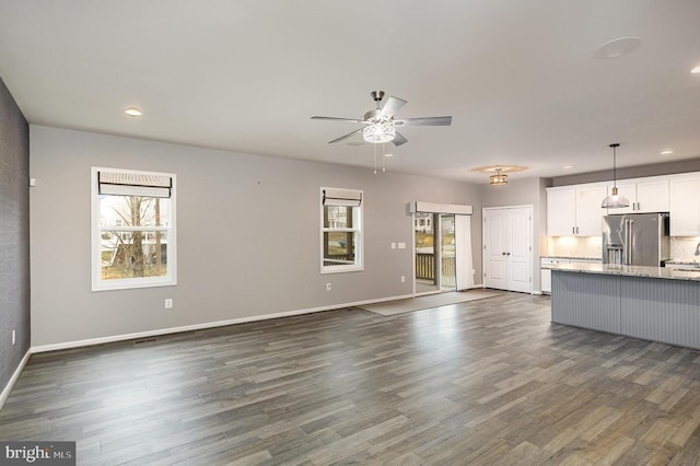 unfurnished living room with dark wood finished floors, recessed lighting, a ceiling fan, and baseboards