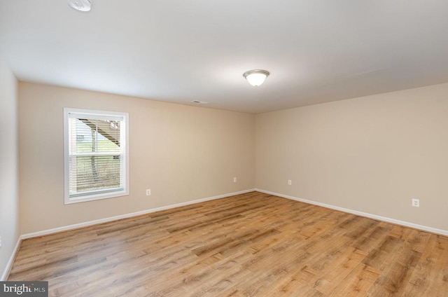 empty room with light wood-style floors and baseboards