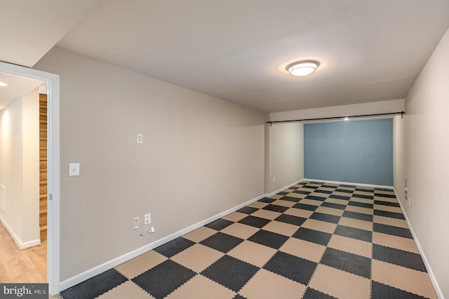 unfurnished room with baseboards