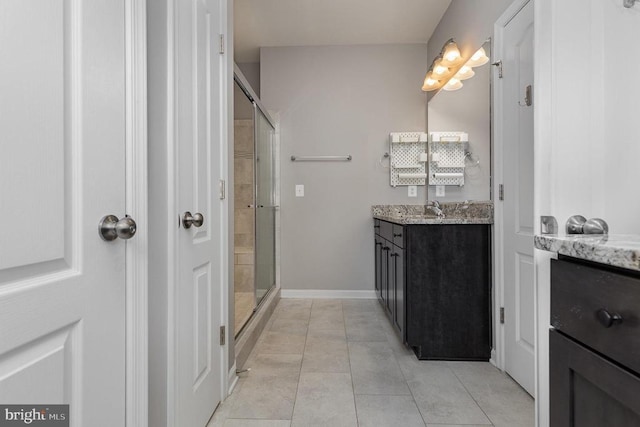 full bath with tile patterned floors, a shower stall, vanity, and baseboards