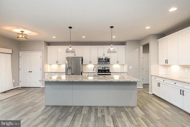 kitchen featuring a sink, an island with sink, white cabinetry, and stainless steel appliances