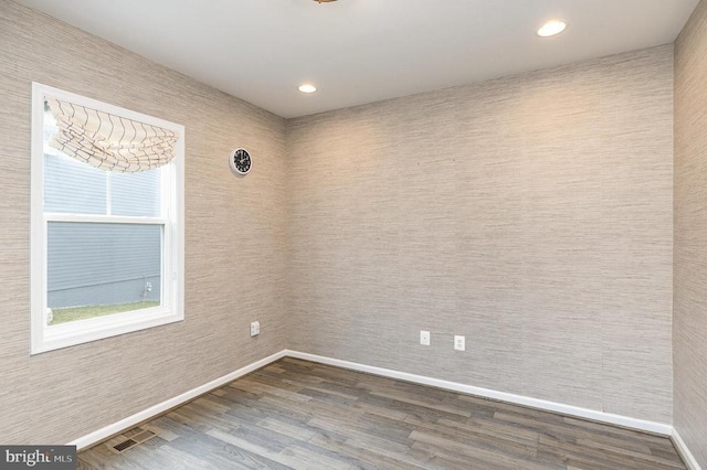 empty room featuring recessed lighting, baseboards, visible vents, and dark wood-style flooring