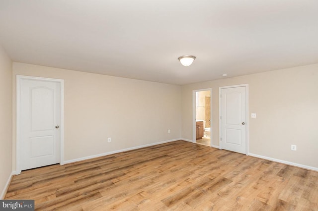 unfurnished room featuring baseboards and light wood finished floors