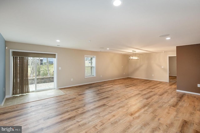 empty room with recessed lighting, baseboards, and light wood finished floors