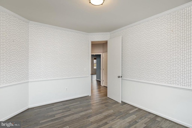 empty room with a wainscoted wall, wallpapered walls, wood finished floors, and ornamental molding