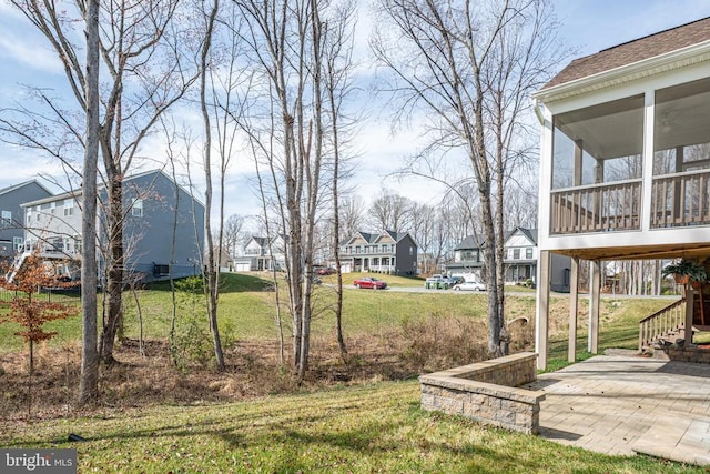 view of yard with stairs, a residential view, and a sunroom