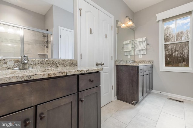 bathroom featuring visible vents, a stall shower, tile patterned flooring, baseboards, and vanity