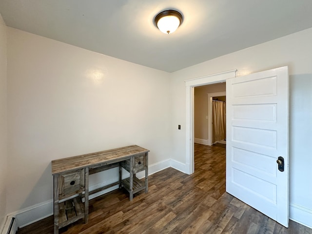 unfurnished room with baseboard heating and dark hardwood / wood-style flooring