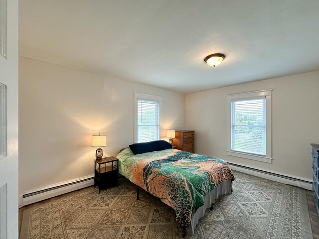 bedroom with baseboard heating and multiple windows