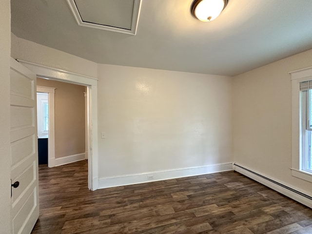 empty room with dark wood-type flooring and baseboard heating