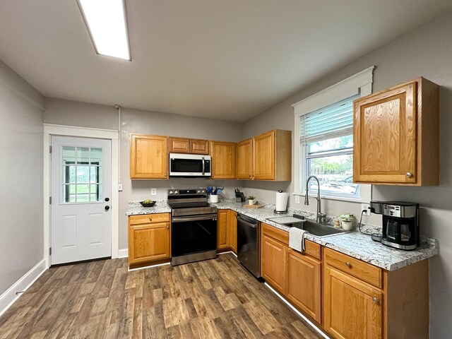 kitchen featuring dark wood-type flooring, stainless steel electric range oven, dishwasher, and sink