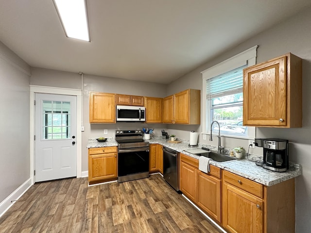 kitchen featuring dark wood-type flooring, stainless steel electric range oven, dishwasher, and sink