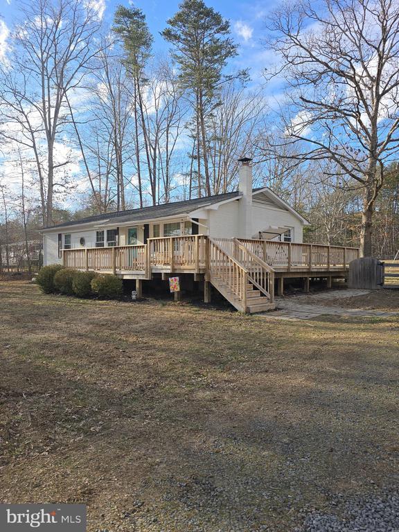 rear view of house with a chimney and a wooden deck