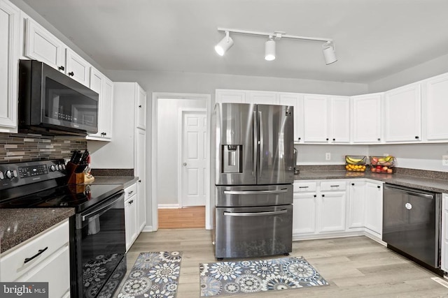 kitchen with light hardwood / wood-style flooring, stainless steel appliances, white cabinetry, and backsplash