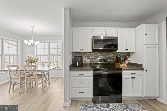 kitchen featuring white cabinets, hanging light fixtures, appliances with stainless steel finishes, and tasteful backsplash