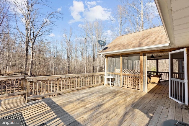 wooden deck featuring ceiling fan and a sunroom