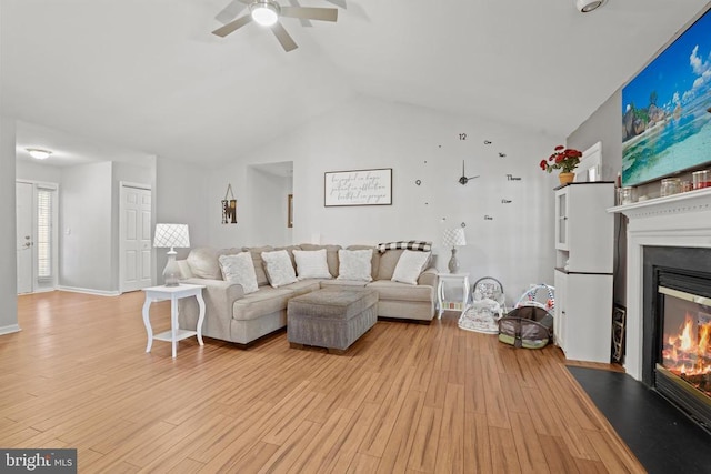 living room featuring ceiling fan, vaulted ceiling, and light hardwood / wood-style floors