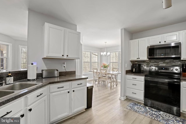 kitchen featuring white cabinets, electric stove, and light hardwood / wood-style flooring