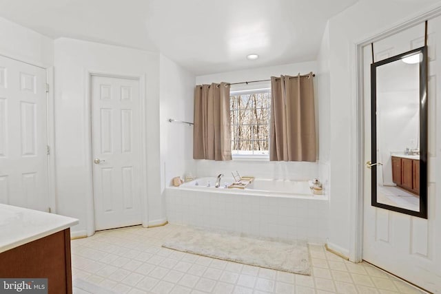 bathroom with vanity and a relaxing tiled tub