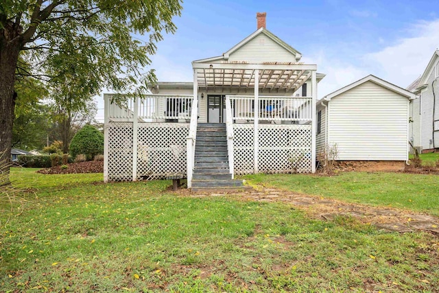 back of property with a wooden deck, a lawn, and a pergola