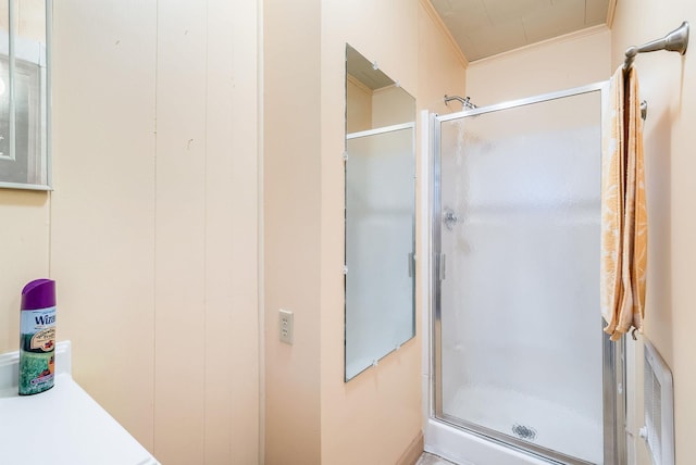 bathroom with crown molding and a shower with shower door