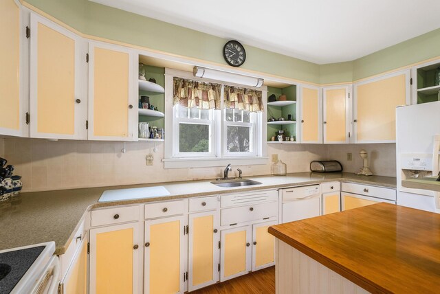 kitchen featuring white appliances, sink, and backsplash