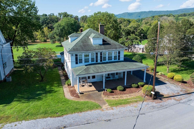 view of front of house with a front yard, a carport, and a porch