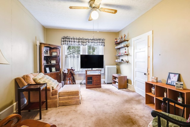 living room featuring radiator, a textured ceiling, ceiling fan, and carpet