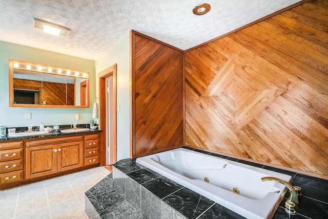 bathroom featuring vanity, tiled bath, and a textured ceiling