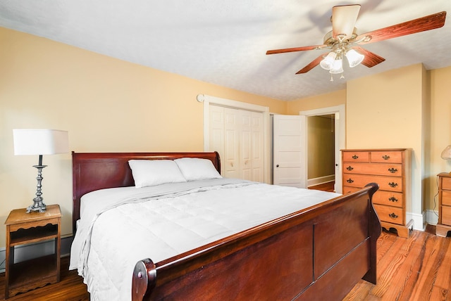 bedroom with ceiling fan, wood-type flooring, and a closet