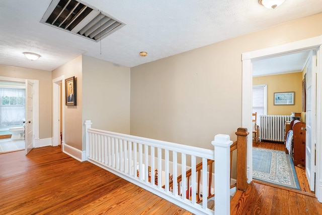 corridor featuring hardwood / wood-style flooring and radiator heating unit