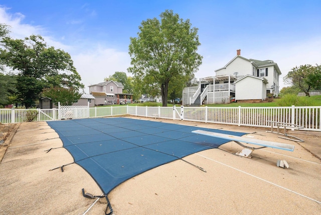 view of swimming pool featuring a diving board and a patio area