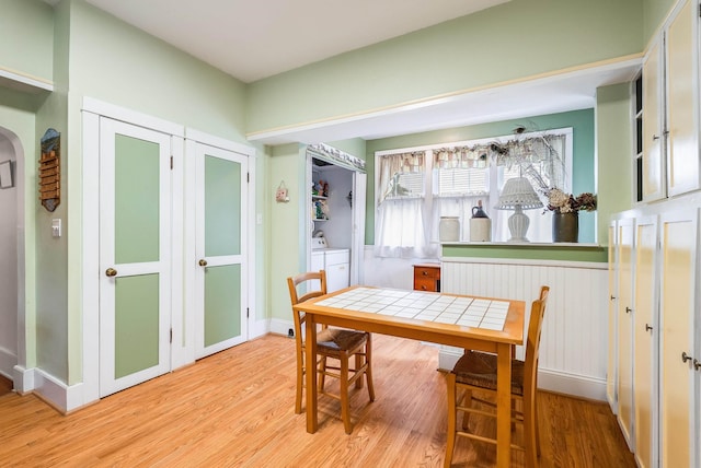 dining room featuring independent washer and dryer and light hardwood / wood-style flooring