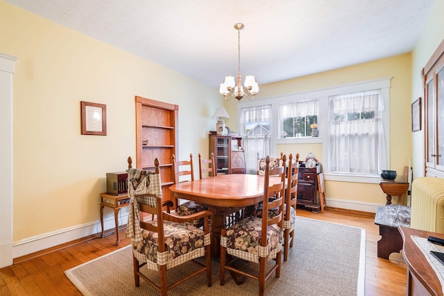 dining area with a chandelier and light hardwood / wood-style flooring