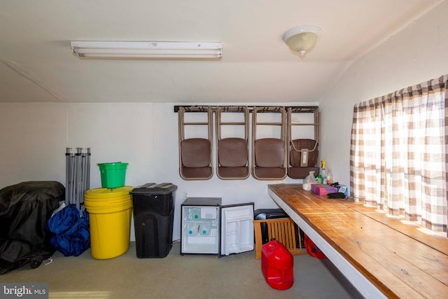 kitchen with lofted ceiling, a wall mounted AC, and wooden counters