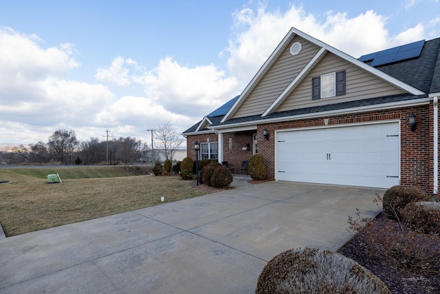 view of front of house with a garage, a front yard, and solar panels