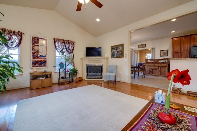 living room with ceiling fan, lofted ceiling, and hardwood / wood-style floors