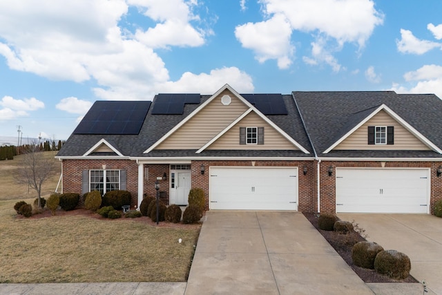 view of front of house featuring a garage, a front yard, and solar panels