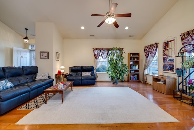 living room with hardwood / wood-style flooring, vaulted ceiling, and ceiling fan