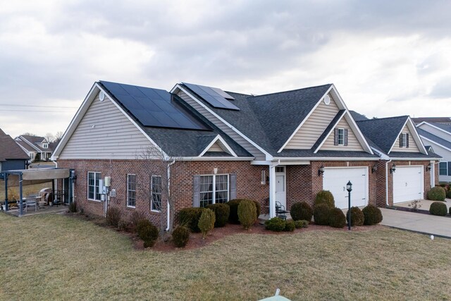 view of front of house with a garage, a front lawn, and solar panels