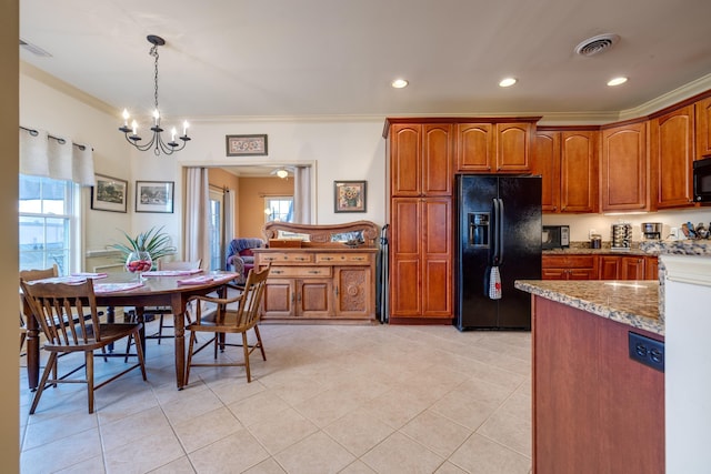 kitchen featuring light tile patterned flooring, hanging light fixtures, light stone counters, black appliances, and crown molding