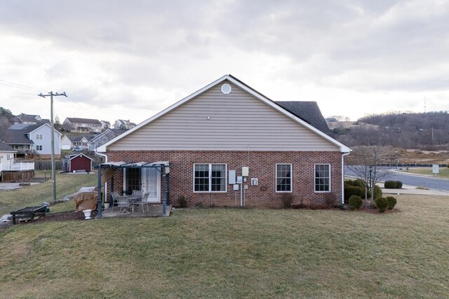 back of property with a yard and a patio area