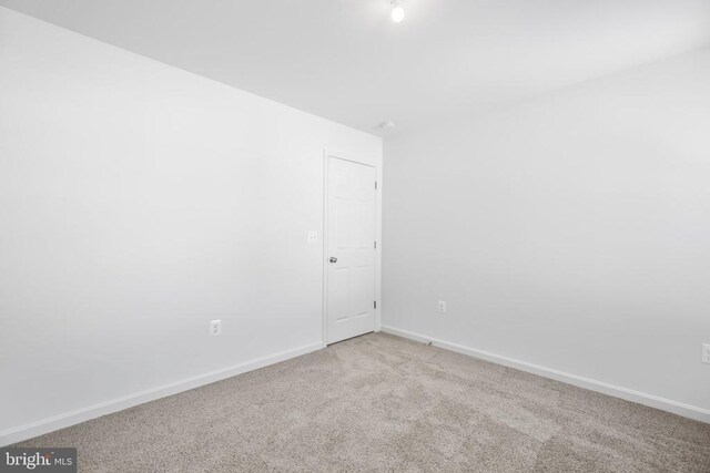 spare room featuring light colored carpet