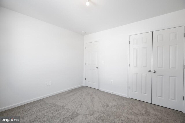 unfurnished bedroom featuring a closet and carpet flooring