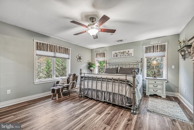 bedroom featuring visible vents, ceiling fan, baseboards, and wood finished floors