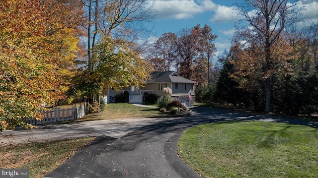 view of front of house featuring driveway, an attached garage, fence, and a front yard